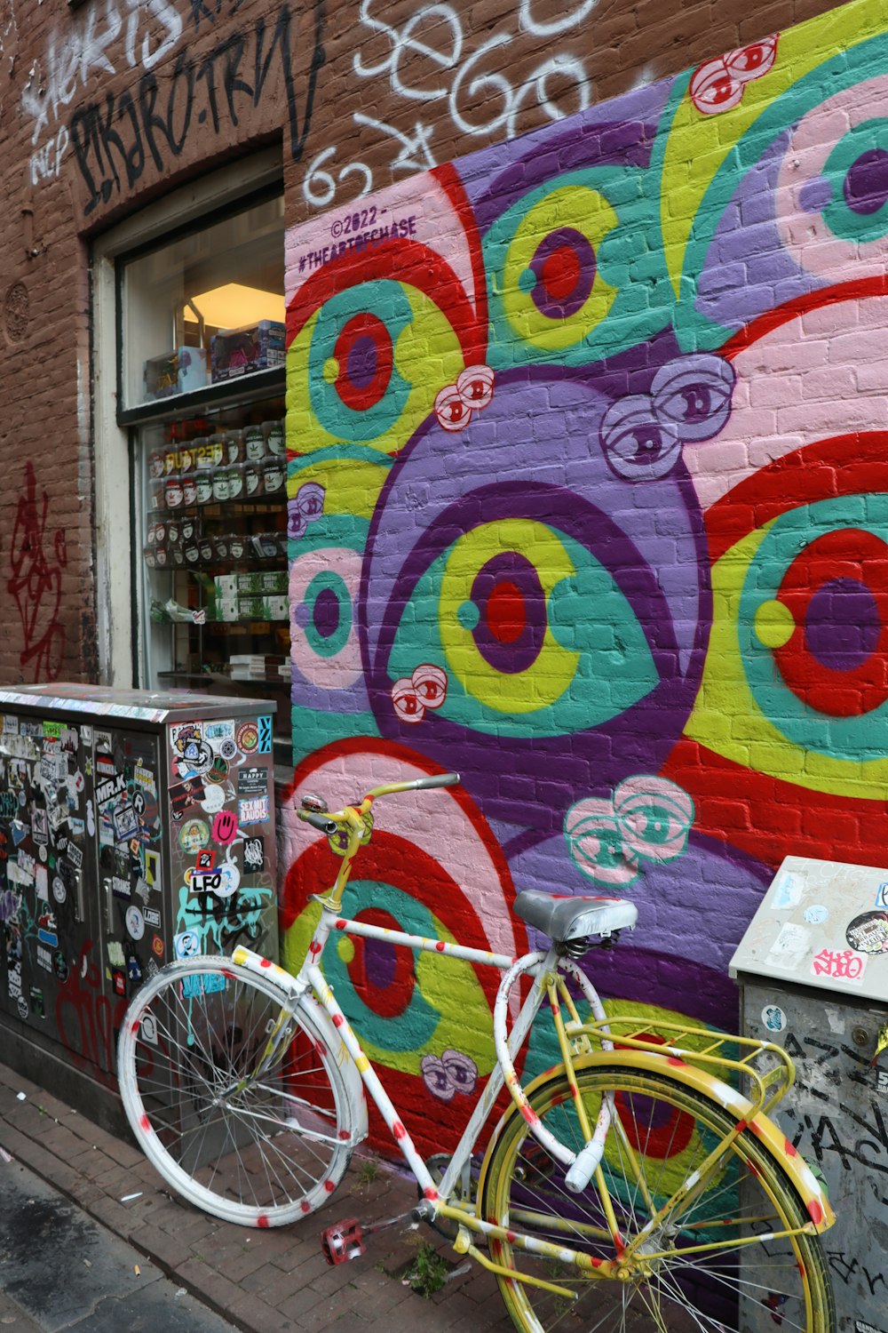 a bicycle is parked in front of a graffiti covered building