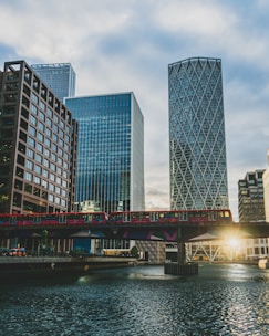 a bridge over a river with tall buildings in the background