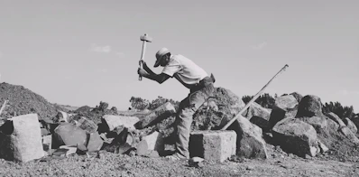 a man with a shovel on a rocky hill