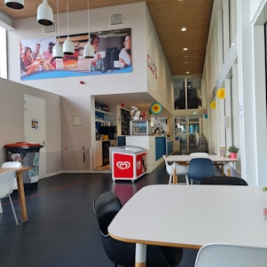 A vibrant café interior with customers enjoying their drinks and a marketing display on the wall.