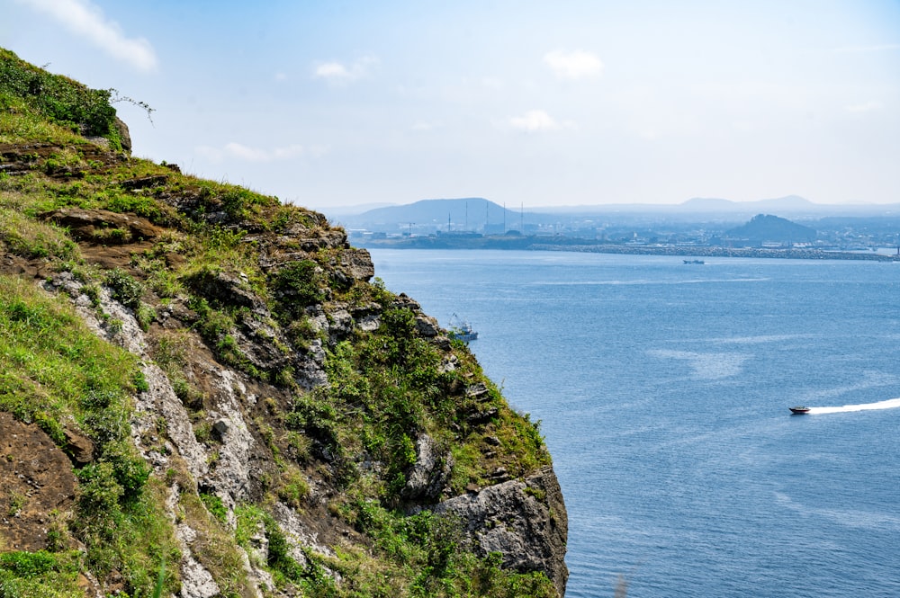 a cliff side with a body of water below