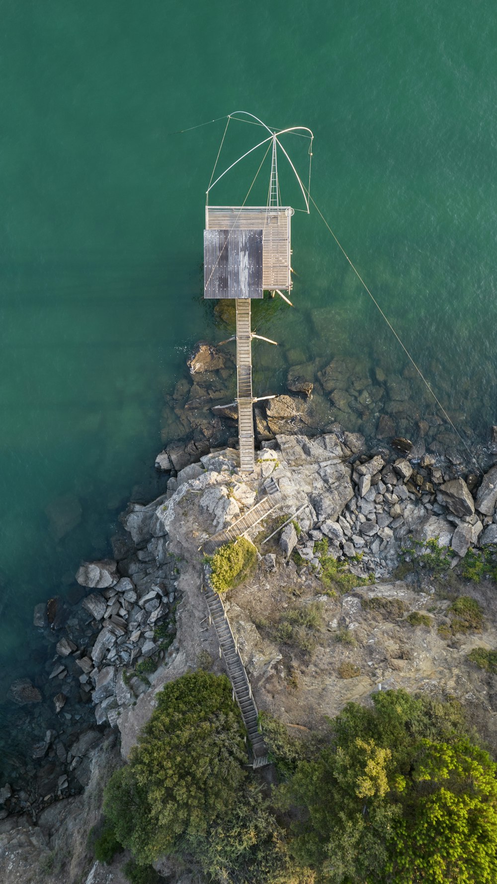 uma torre de madeira em uma colina rochosa