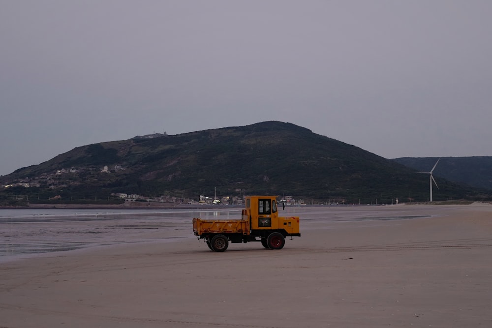 a yellow truck on a beach