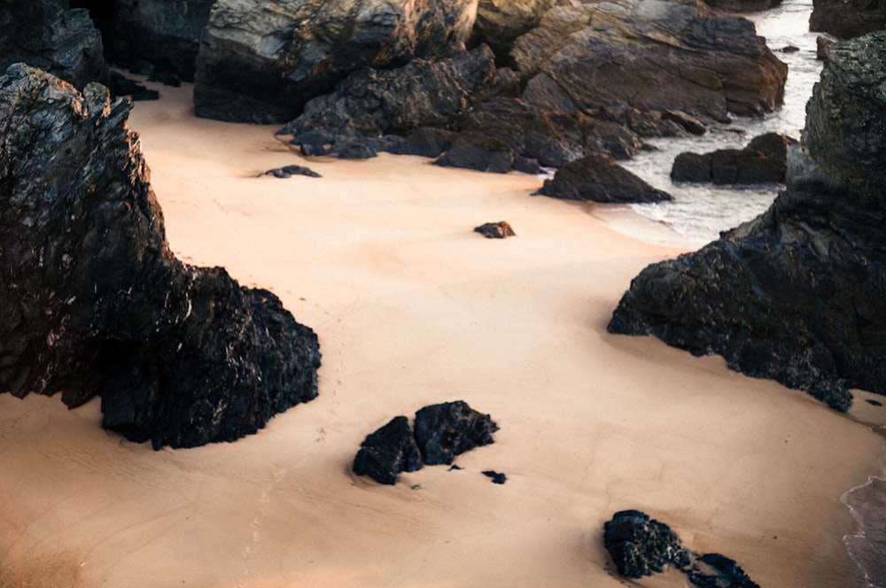 a rocky beach with a body of water in the background