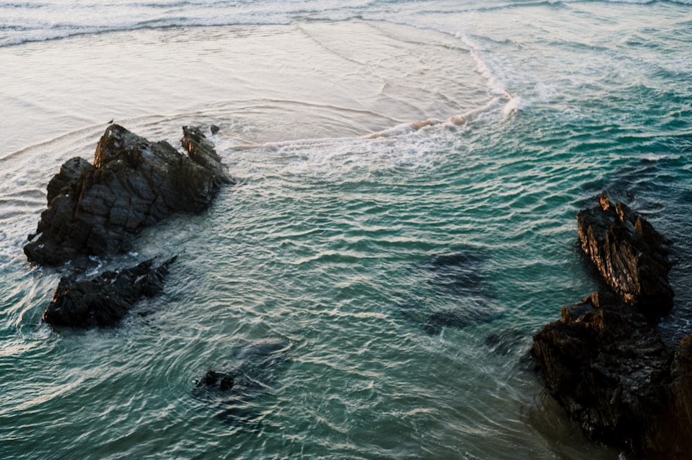 un cuerpo de agua con rocas y olas