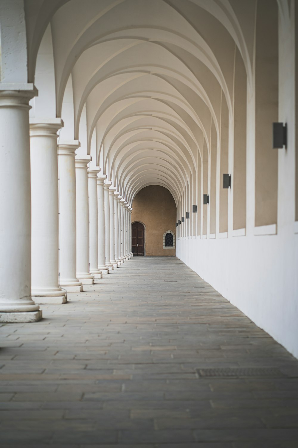 Un couloir avec des piliers blancs