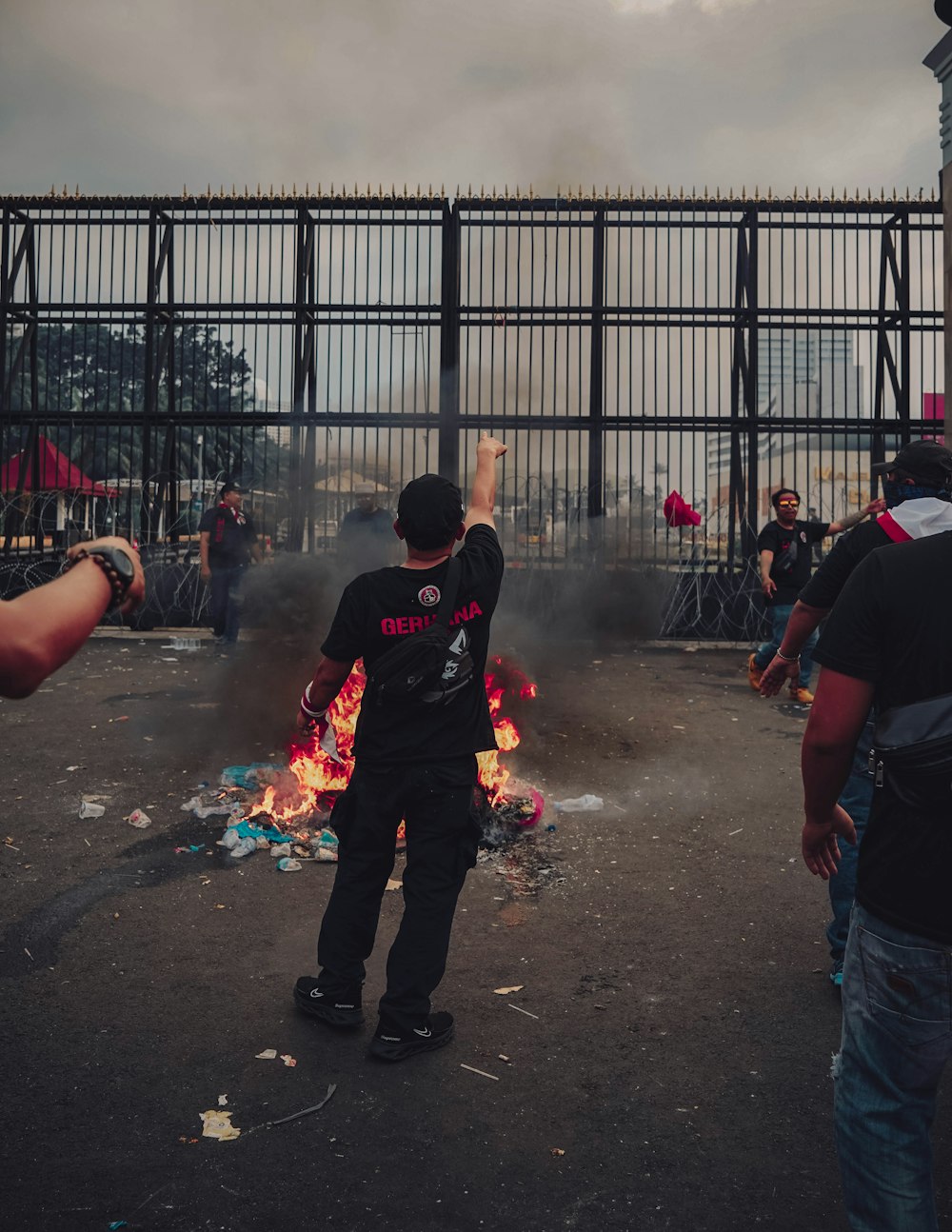 a group of people standing in a fenced in area