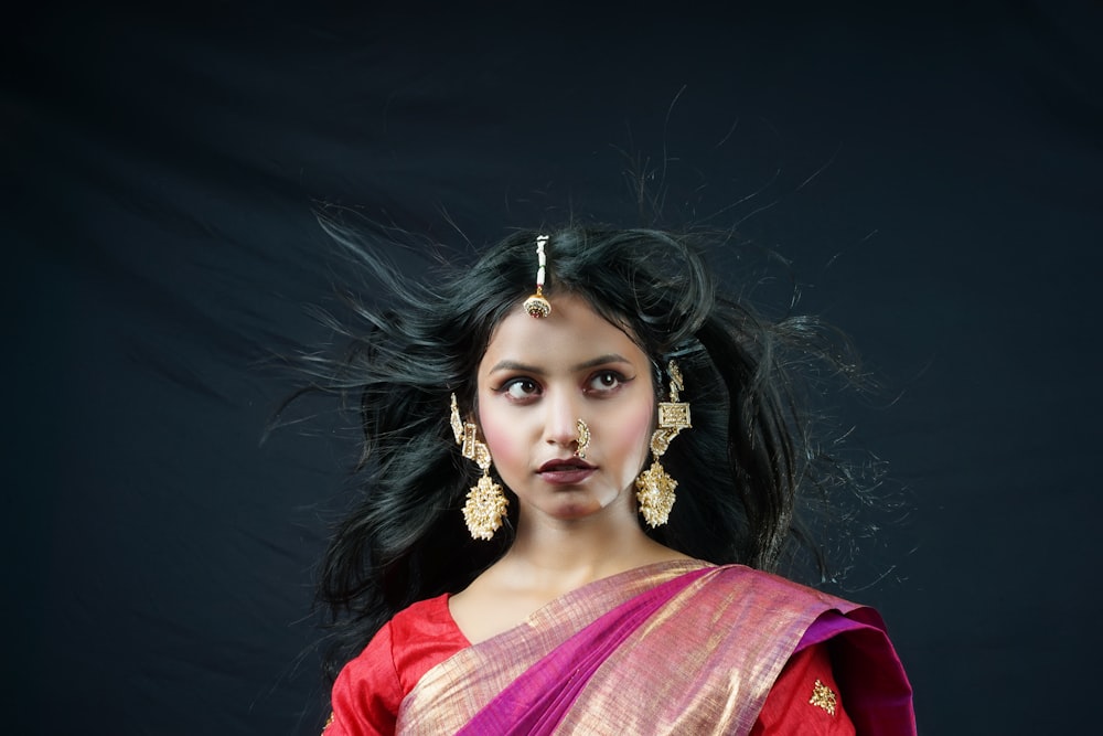 a person with a red and gold dress and a headdress