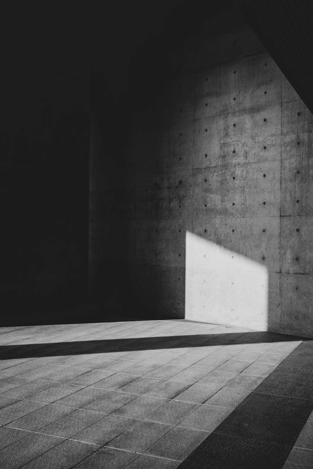 a black and white photo of a wall with a square hole in it