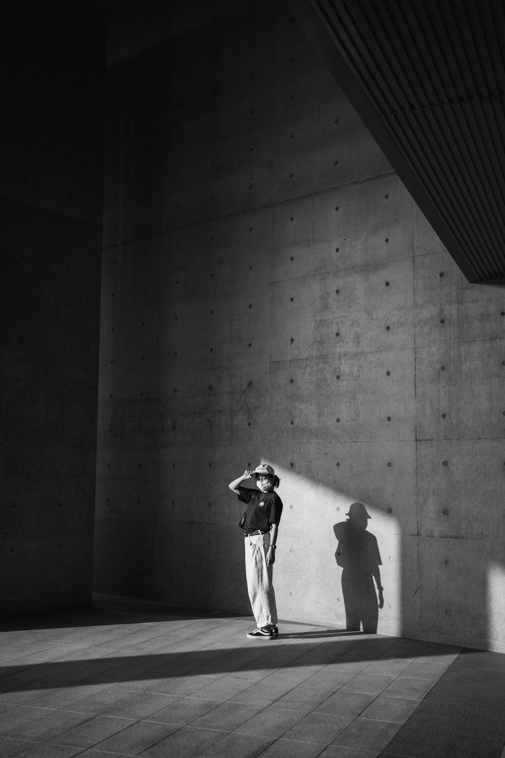 a man standing next to a wall