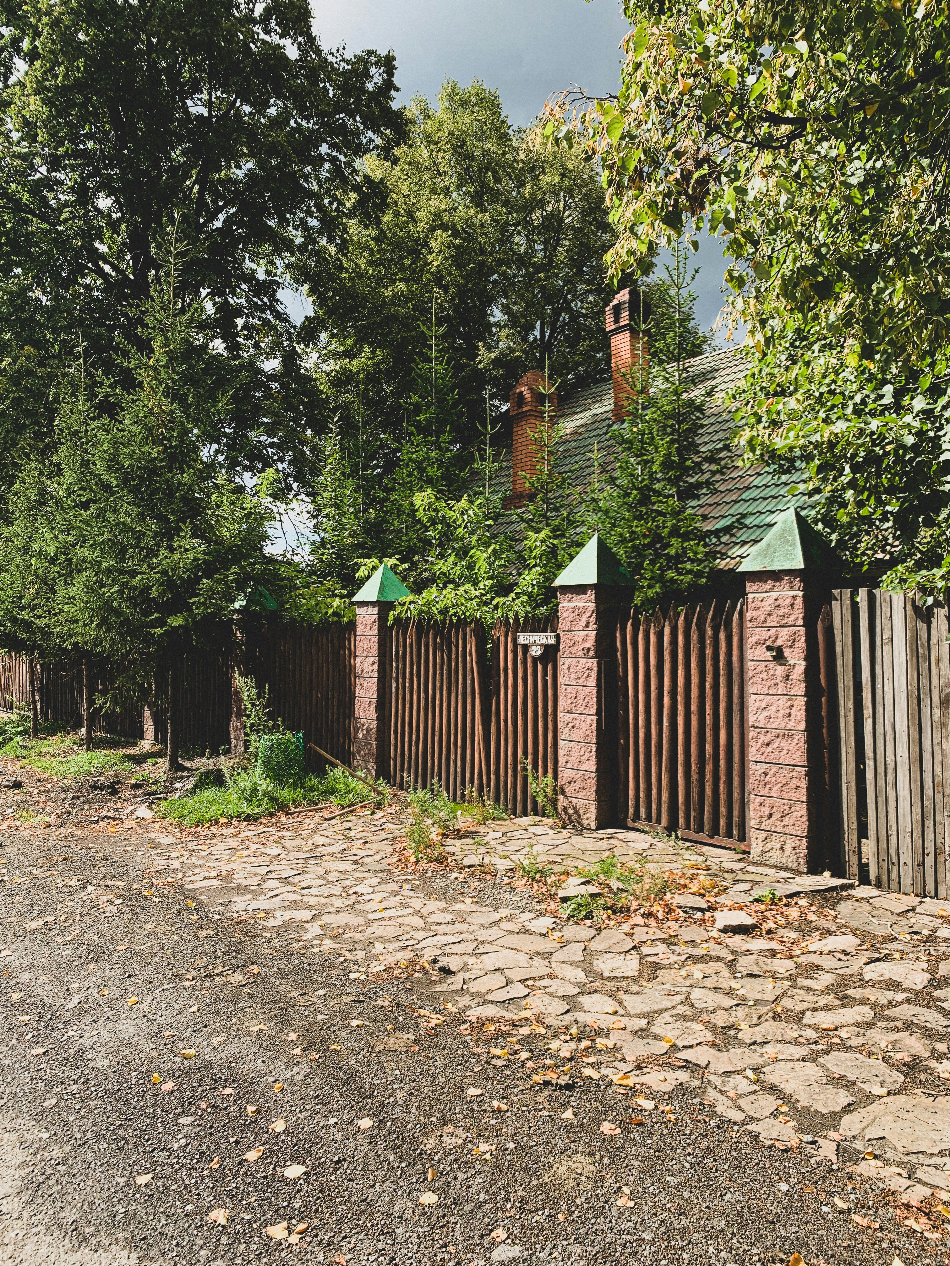 a fenced in yard with a brick building and trees