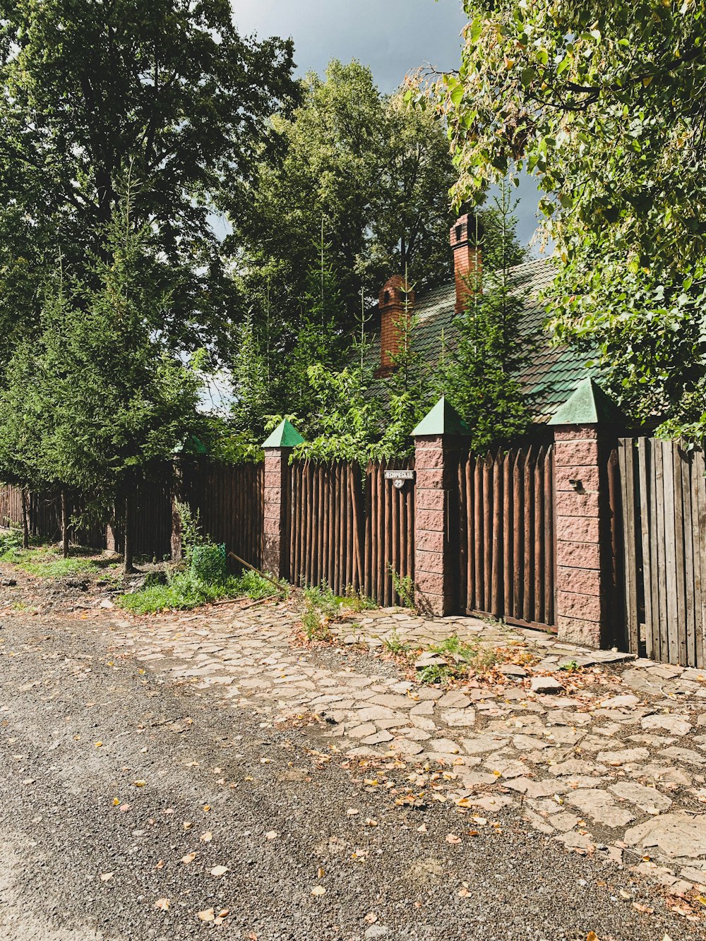 a fenced in yard with a brick building and trees
