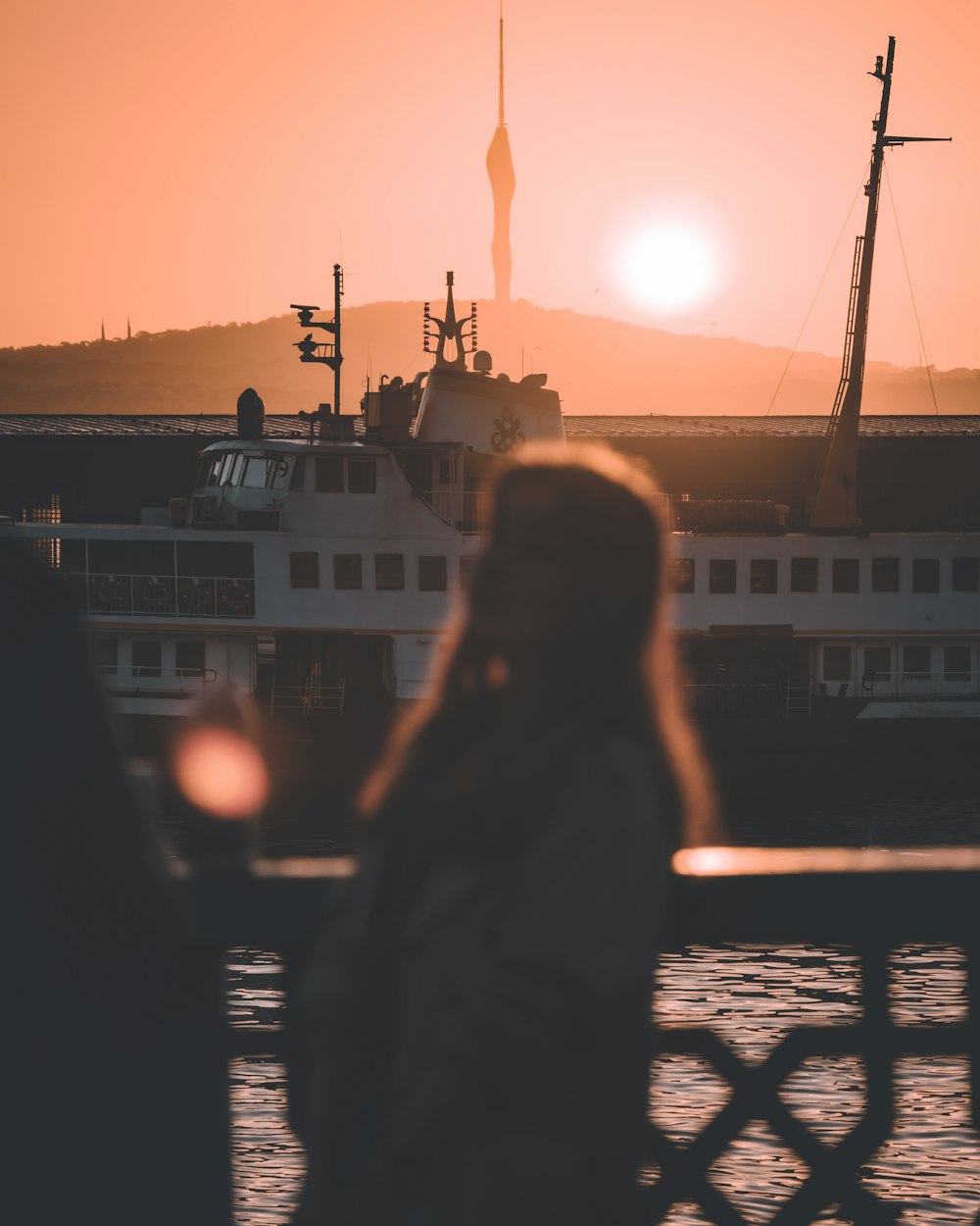 a person standing in front of a boat at sunset