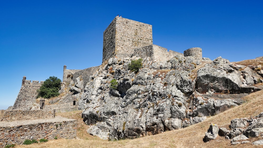 a stone building on a rocky hill