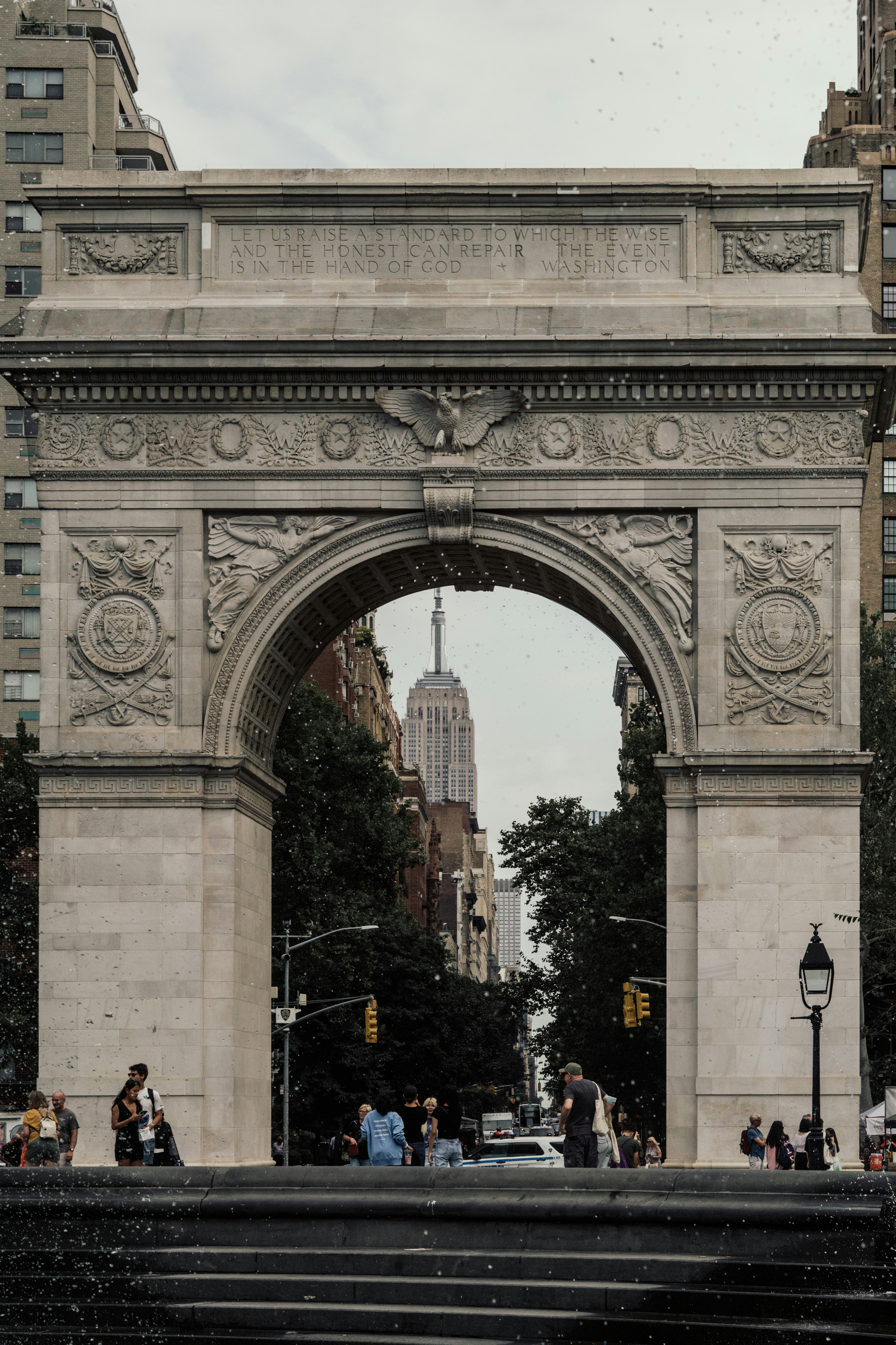 A large stone archway with people walking underneath with Washington ...