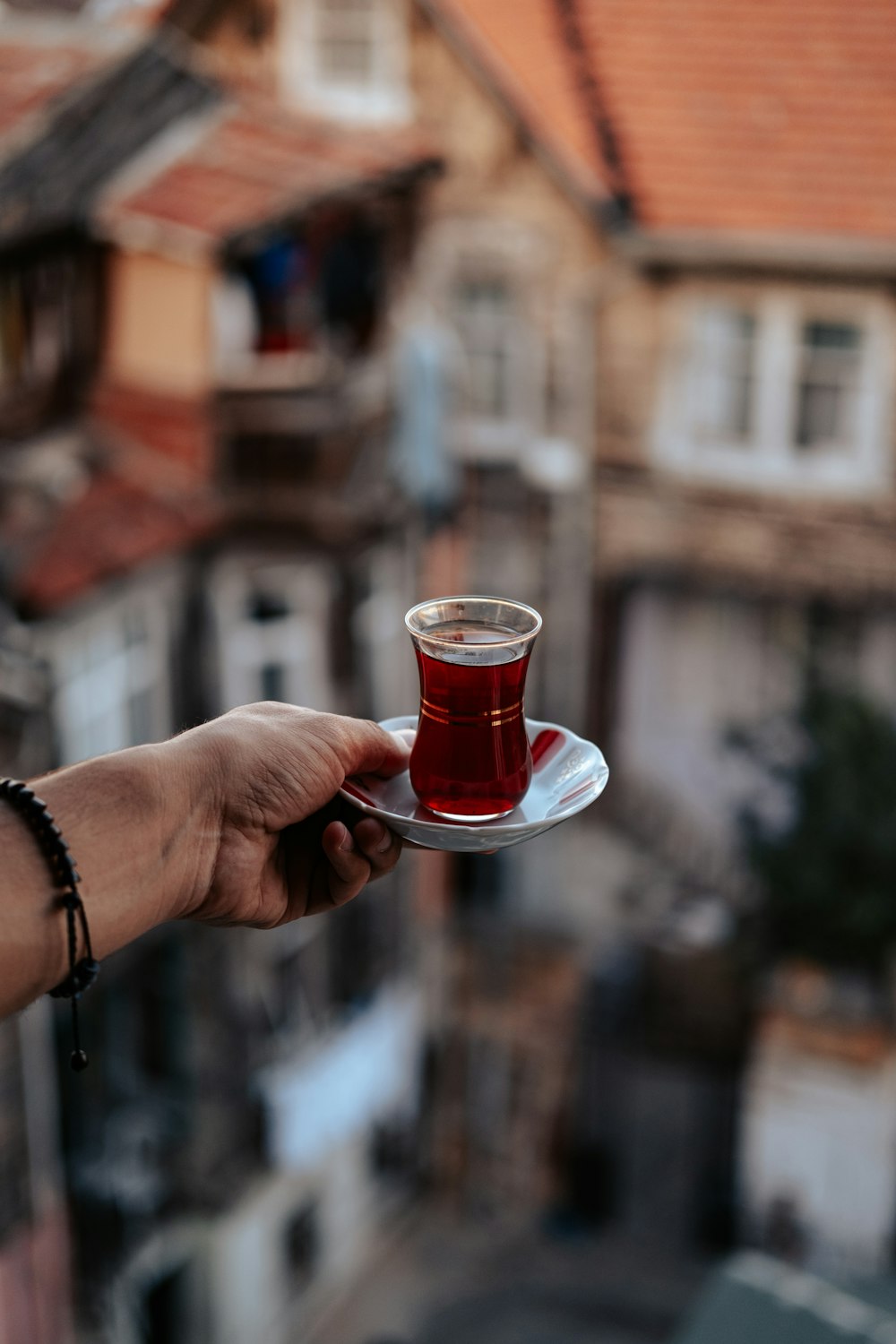 a hand holding a glass of liquid