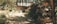 A rustic outdoor setting featuring a dirt pathway leading to a modest wooden house partially obscured by lush greenery. The entrance has various plants and palm leaves, casting shadows on the ground. A stack of bundles or sacks is visible under the shade of a palm tree bearing fruit.