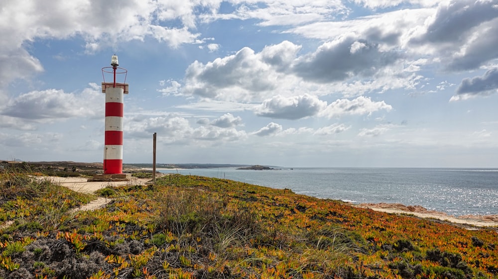 a lighthouse on a hill by the ocean