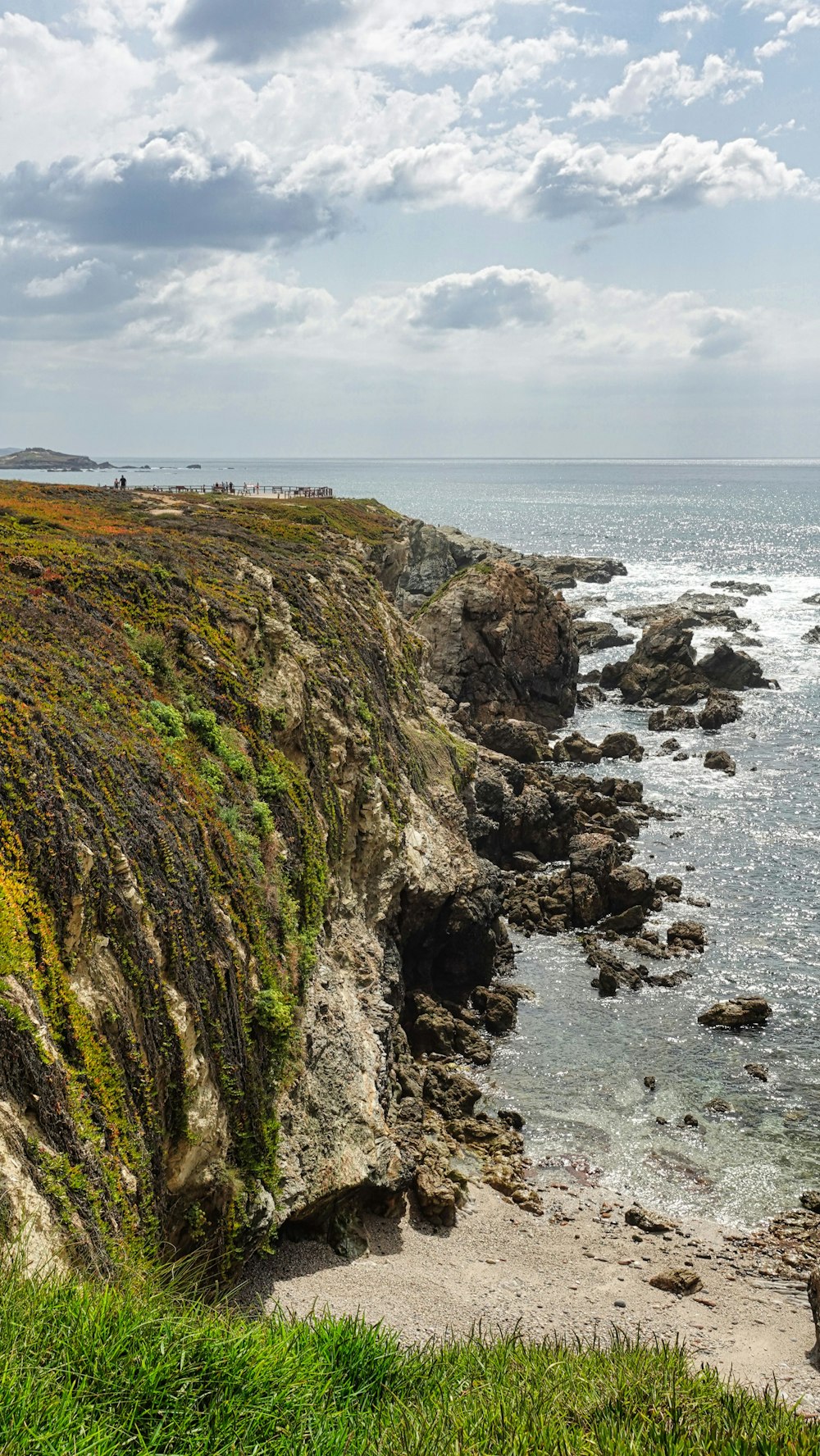 a rocky cliff next to a body of water