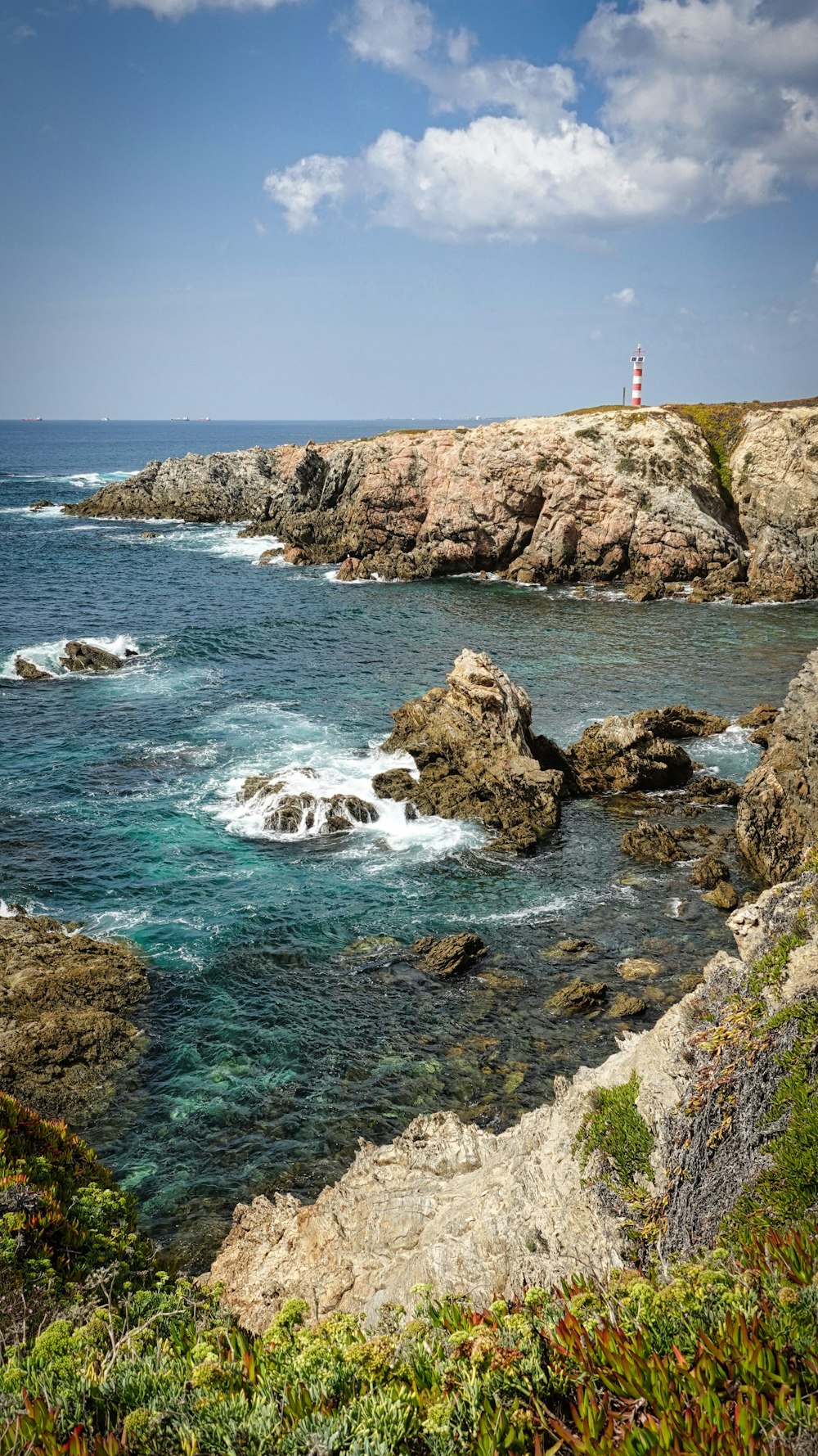 a rocky beach with a lighthouse