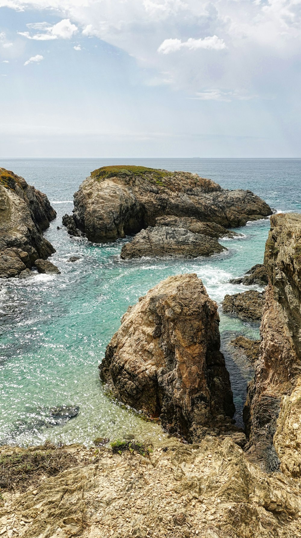 a rocky beach with a body of water in the background