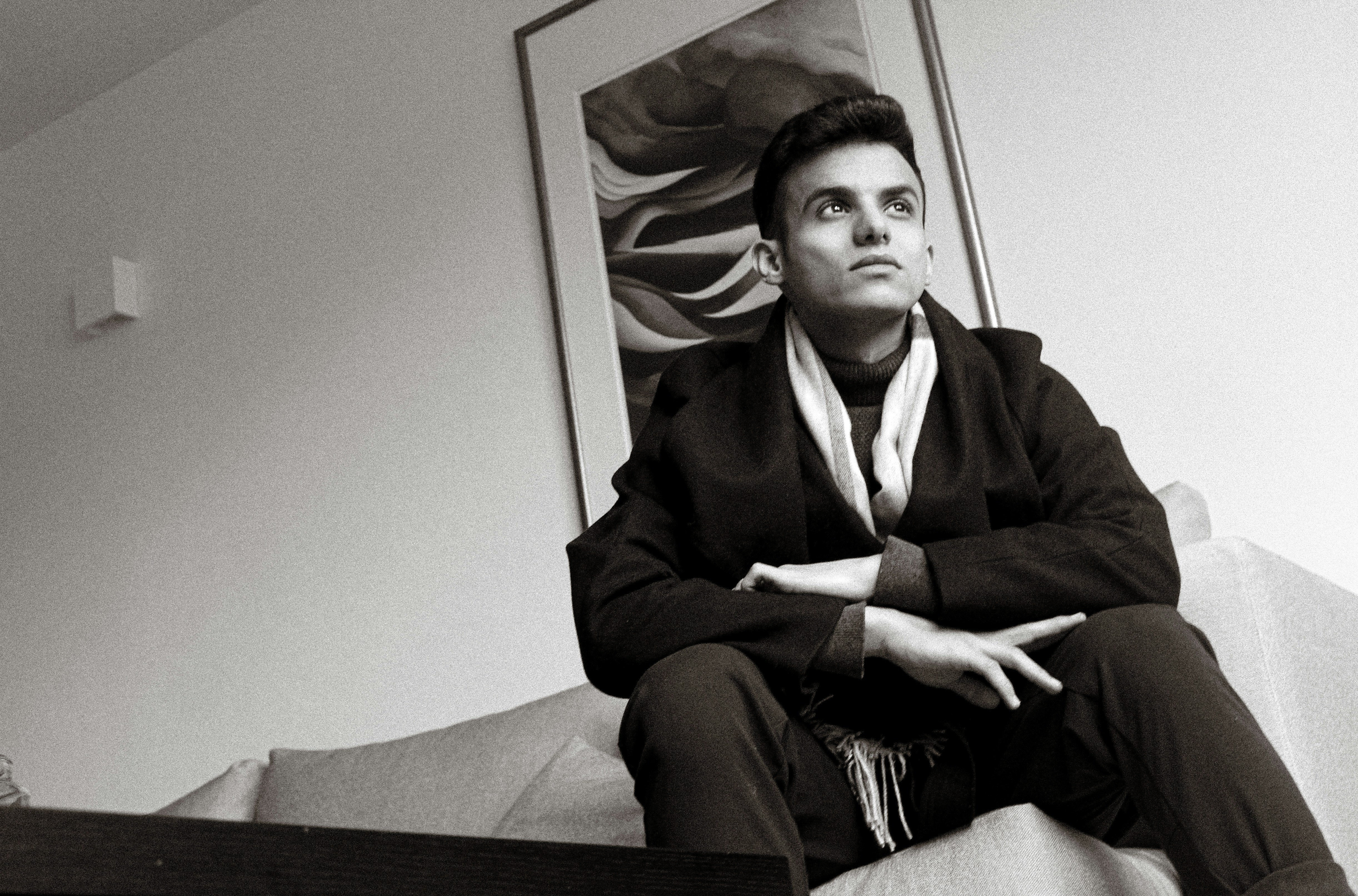 a man sitting on a bed, 