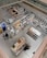Detailed view of a well-organized store section from an elevated perspective. The image features various household items and cookware arranged on shelves and display tables. Shoppers can be seen browsing through the store. The bright lighting and clean, modern design emphasize the neatness and organization. The store has aisles and designated sections for different types of products.