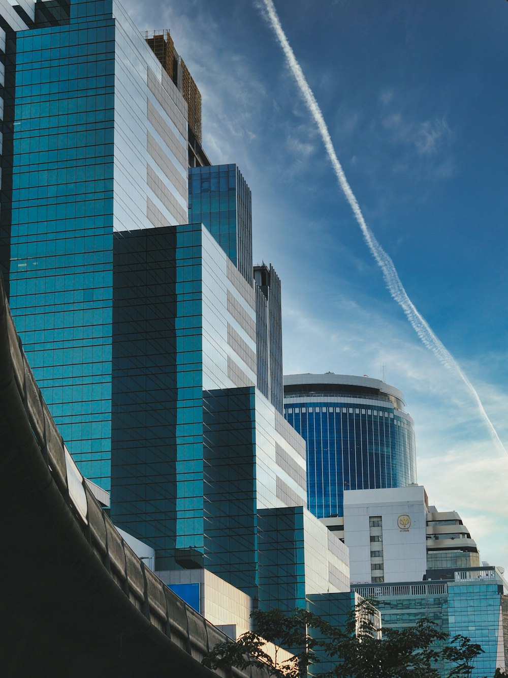 a tall building with a trail of smoke coming out of it