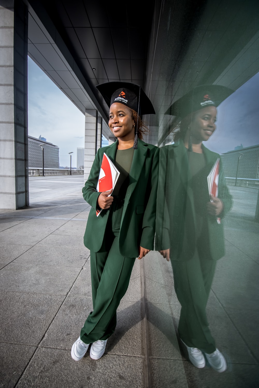 Una mujer con bata de graduación y gorra sosteniendo un diploma