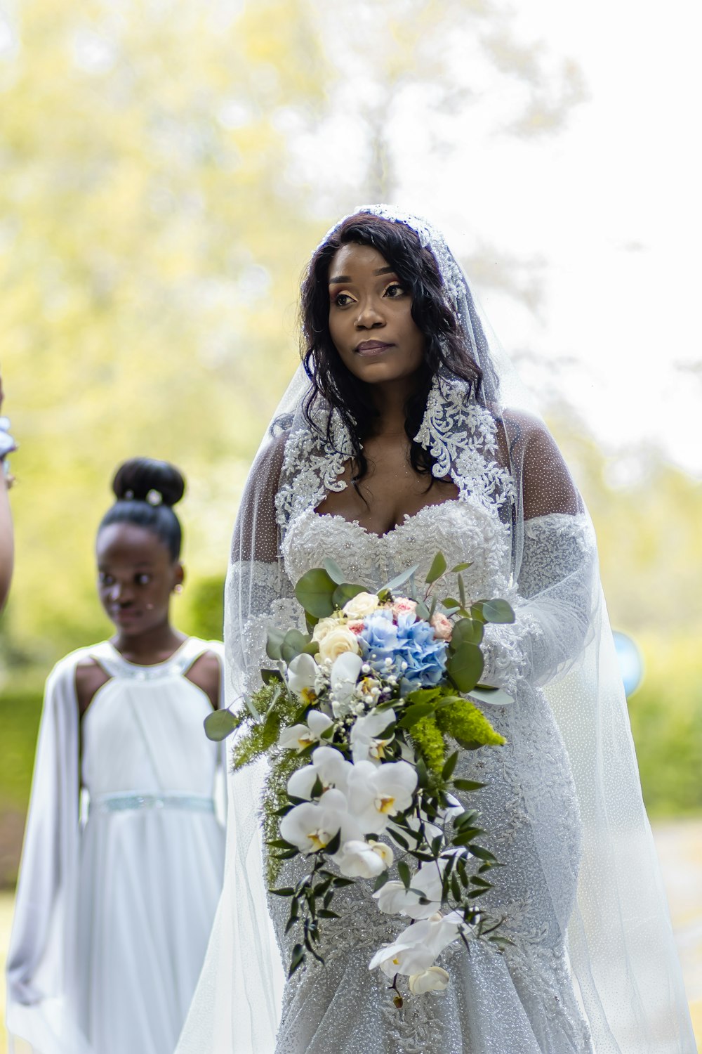 a person in a white dress holding a bouquet of flowers