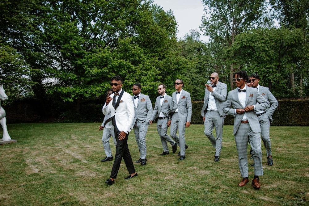 a group of men in suits walking on a path