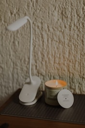 a white coffee maker next to a coffee cup