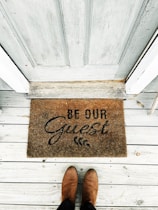 a person's feet on a wooden surface with a sign