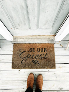 a person's feet on a wooden surface with a sign