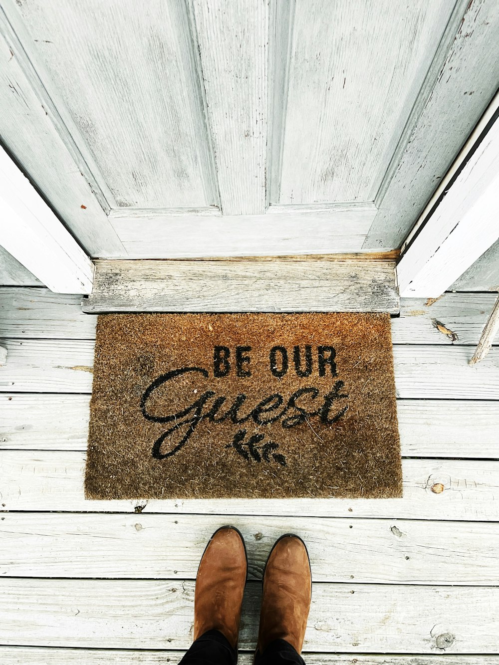 a person's feet on a wooden surface with a sign