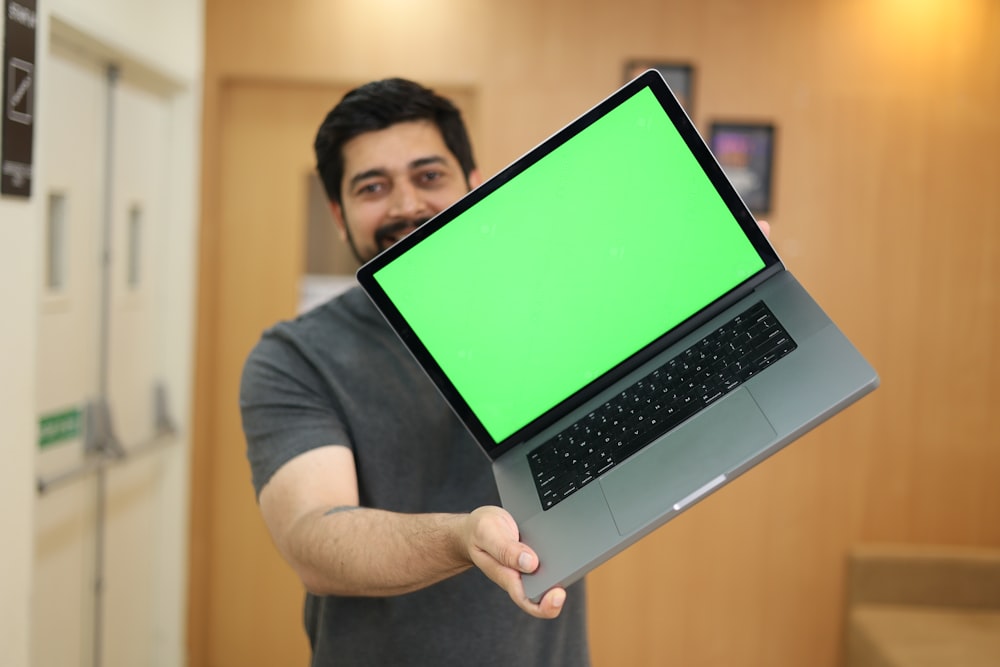 Un hombre sosteniendo una computadora portátil