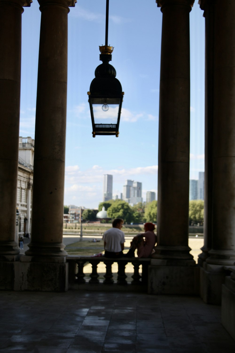 a couple sitting on a bench under a clock tower