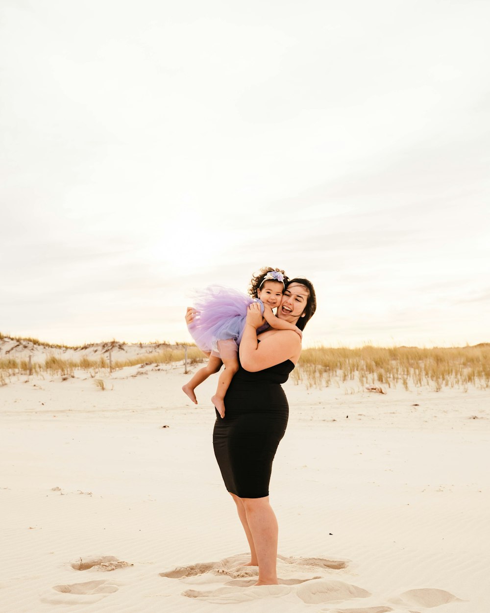 a person holding a baby on a beach