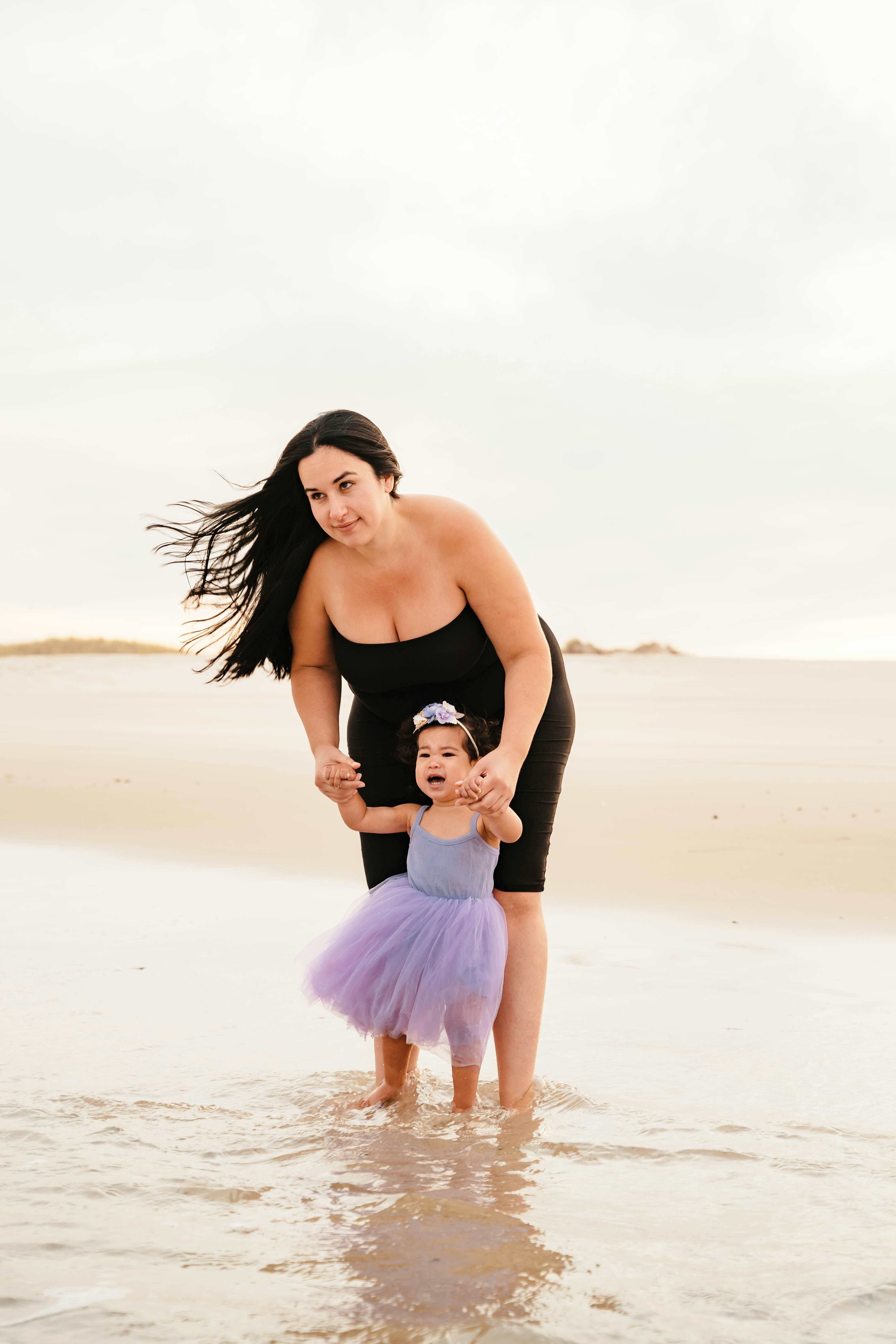 a person holding a child on a beach