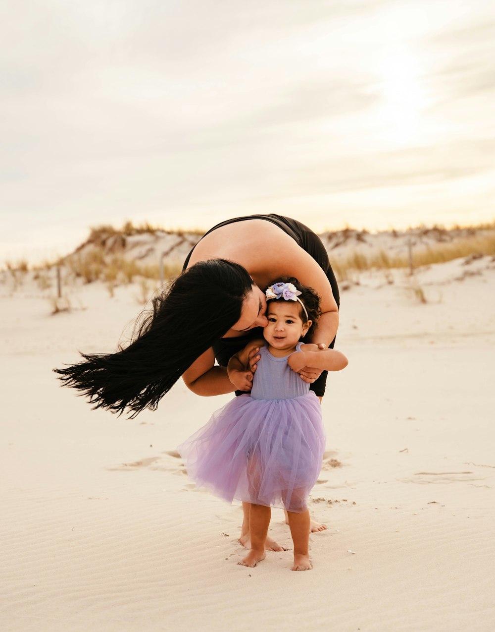 a person holding a baby on a beach