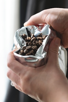 a hand holding a clear container with chocolates in it