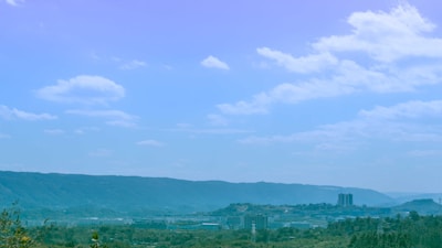 A serene view of Om Swapna City’s landscaped green spaces with walking paths under a clear sky.