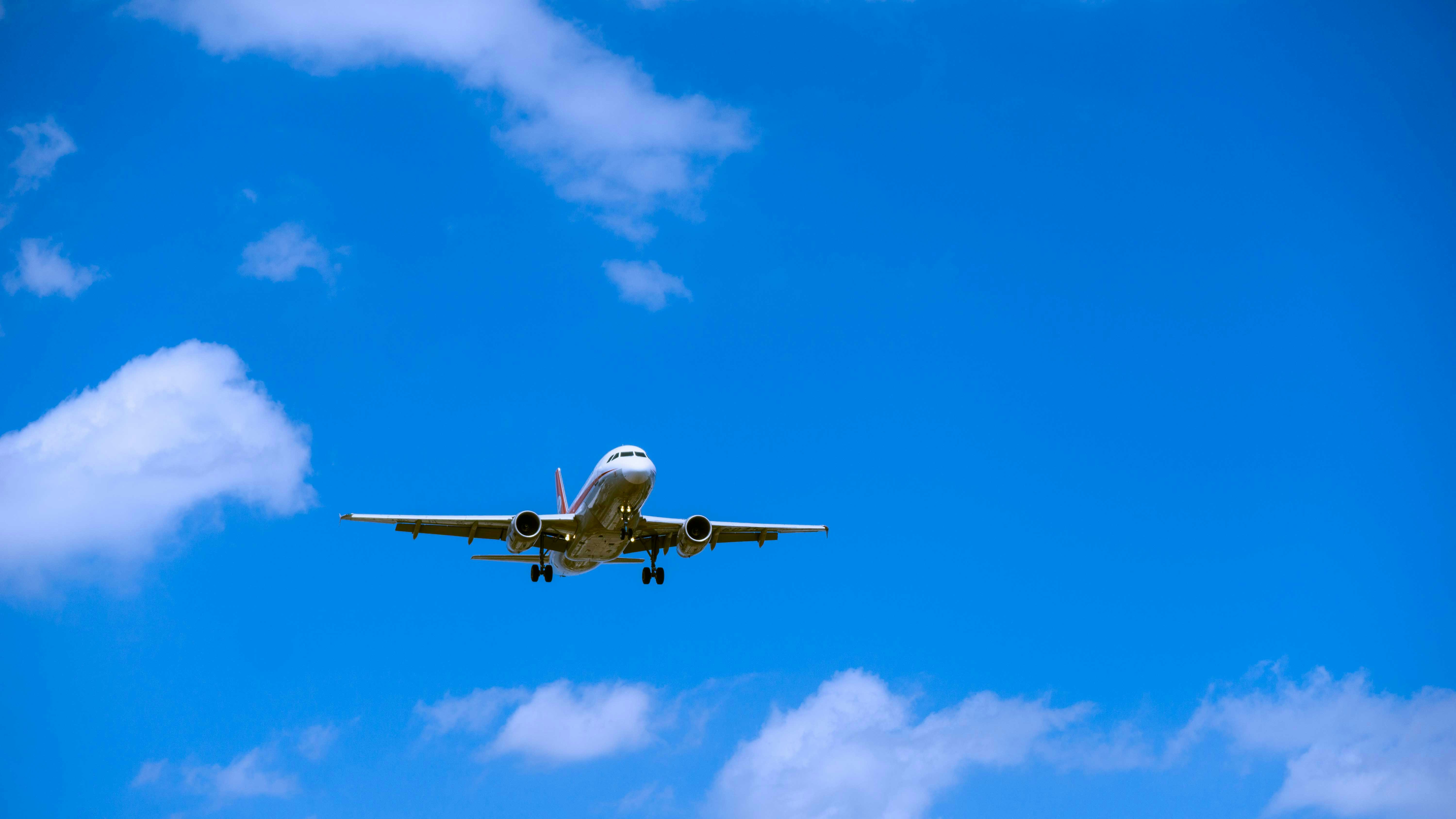 an airplane flying in the sky, A Sichuan Airlines flight is approaching to the Chongqing Jiangbei International Airport in the blue sky.