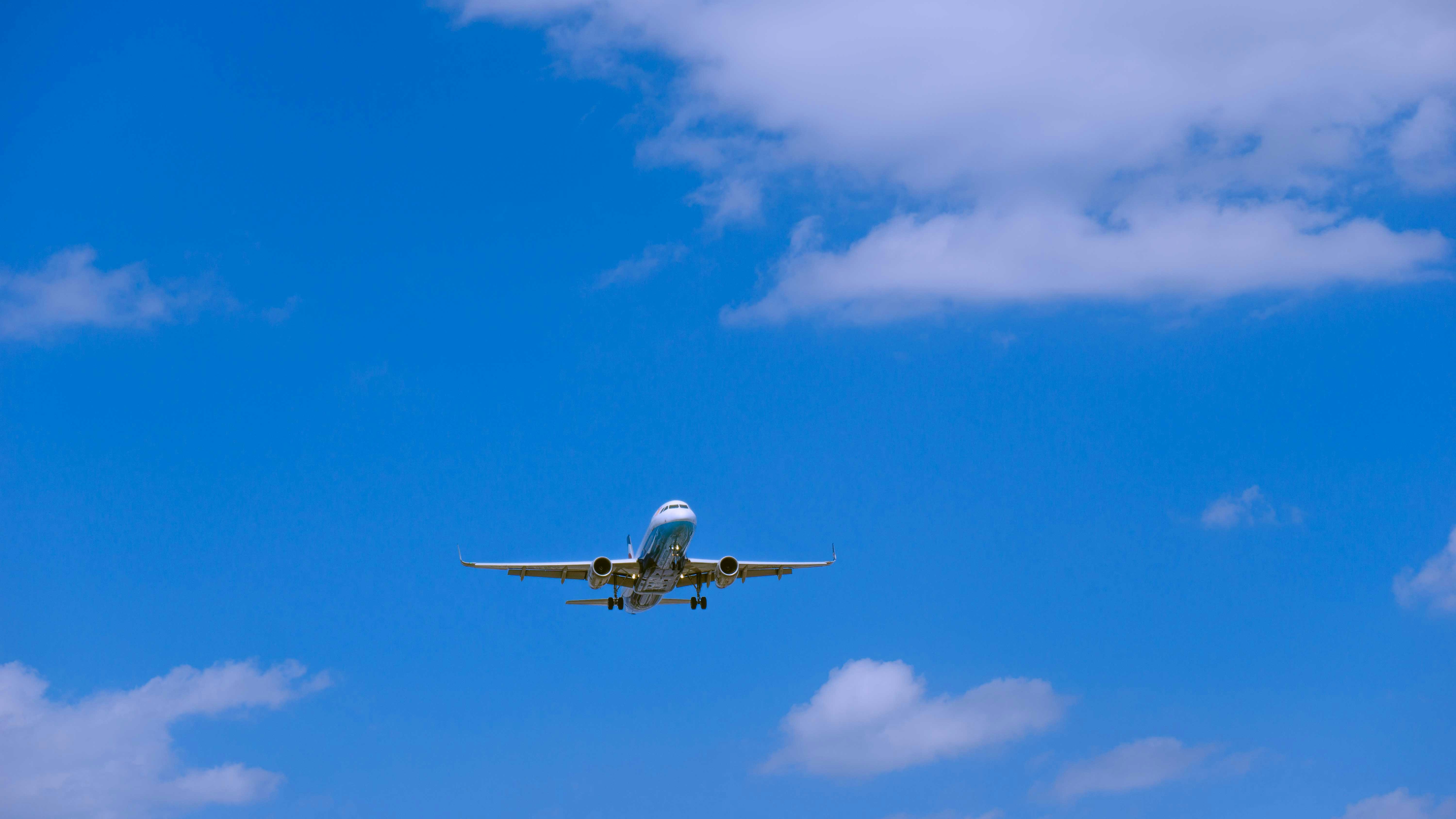 an airplane flying in the sky, A Chongqing Airlines flight is approaching to the Chongqing Jiangbei International Airport in the blue sky.