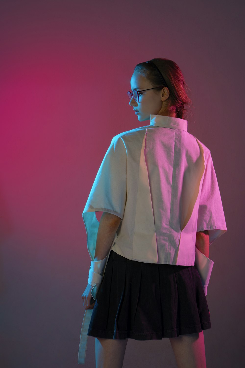 a woman wearing a pink shirt and black skirt