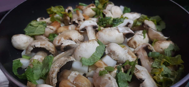 A chef in a restaurant kitchen carefully selecting fresh mushrooms supplied by Uzhavan Shakti.