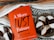 A red book titled "A More Just Future" by Dolly Chugh is placed next to a plate of black and white cookies. The book has text describing it as a tool for psychological and social change. The background includes a striped woven fabric in earthy tones.
