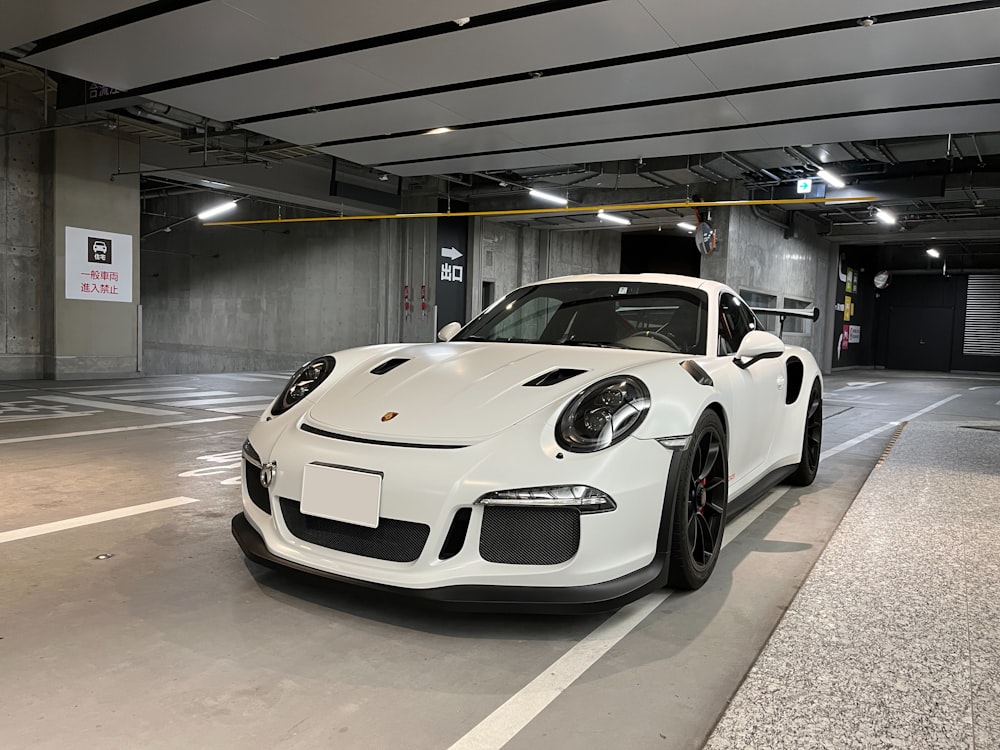 a white sports car parked in a parking garage