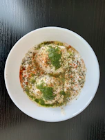 Doi fuchka arranged neatly on a platter, topped with creamy yogurt and tamarind chutney.