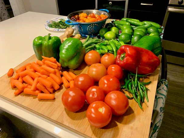 Fresh, vibrant vegetables arranged on a wooden cutting board ready for cooking.